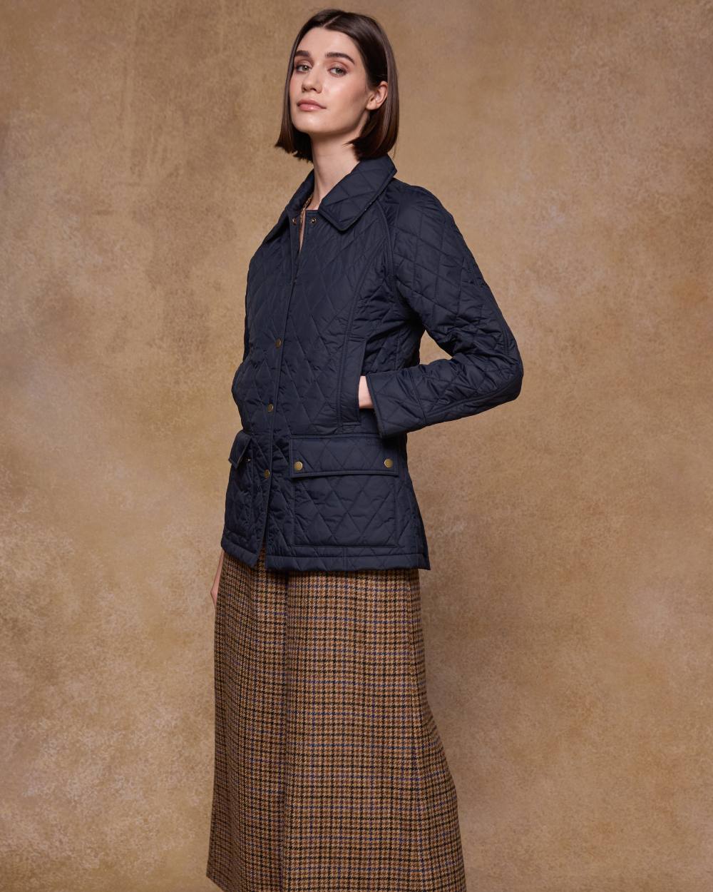 Navy coloured Jack Murphy Womens Molly Quilted Jacket on wall background 