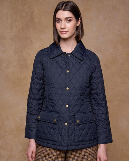 Navy coloured Jack Murphy Womens Molly Quilted Jacket on wall background 