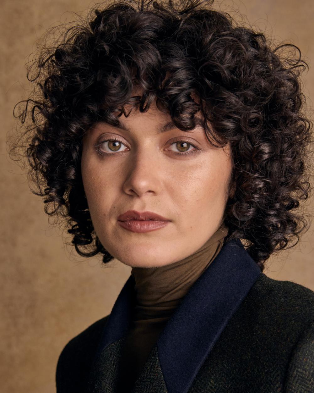 Deep Green Herringbone coloured Jack Murphy Womens Robin Tweed Coat on textured background 