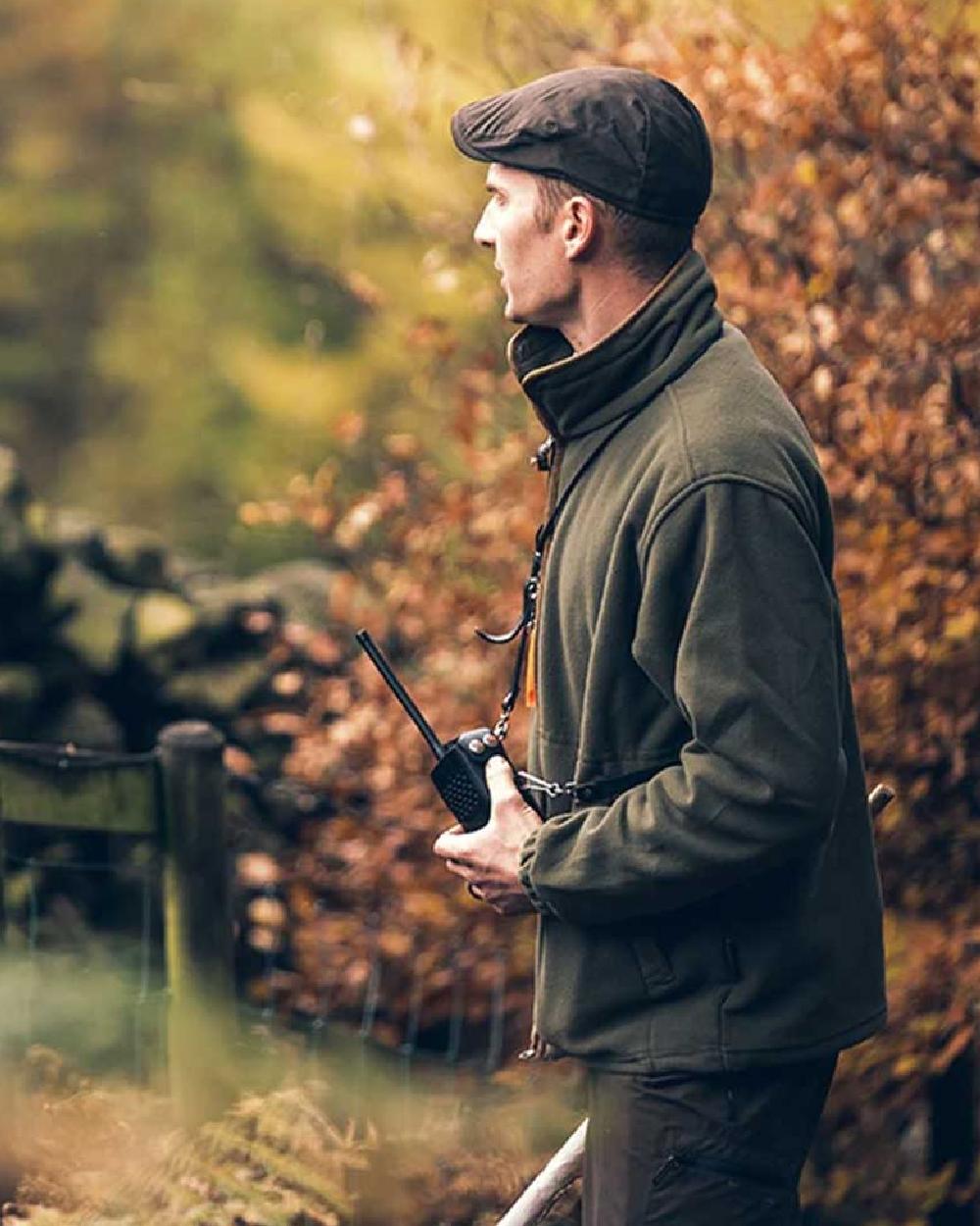 Olive coloured Jack Pyke Ashcombe Flat Cap on tree background 