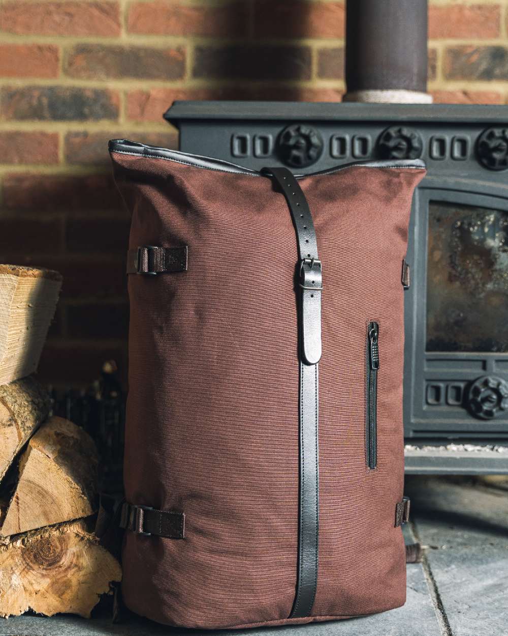 Brown coloured Jack Pyke Canvas Fold Top Rucksack on brick wall background 