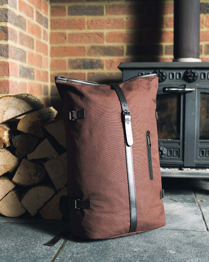 Brown coloured Jack Pyke Canvas Fold Top Rucksack on brick wall background 