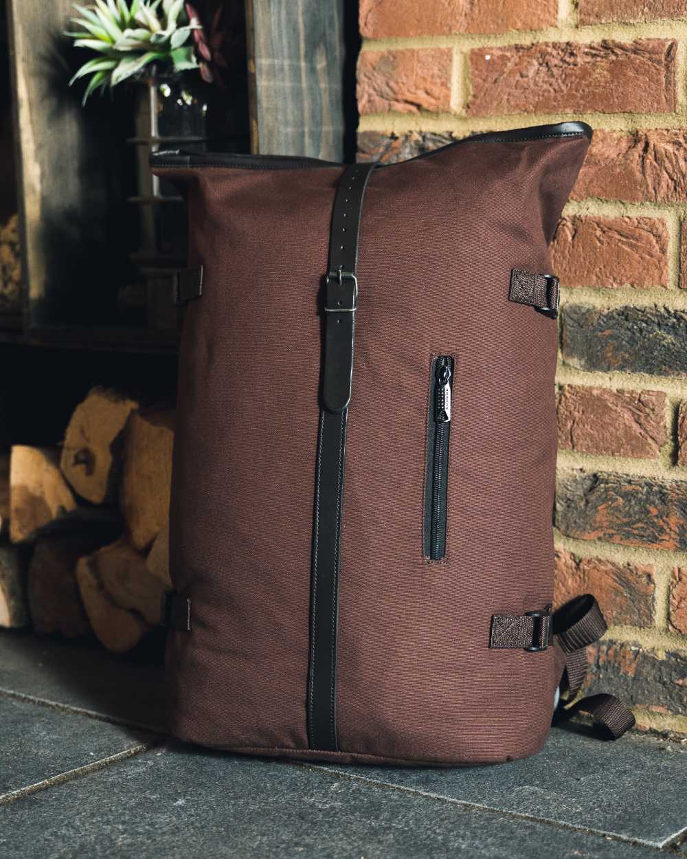 Brown coloured Jack Pyke Canvas Fold Top Rucksack on brick wall background 