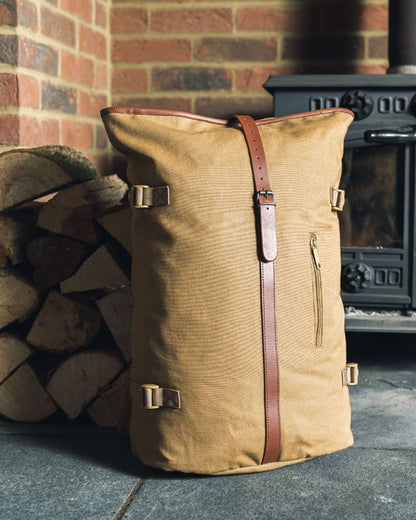 Fawn coloured Jack Pyke Canvas Fold Top Rucksack on brick wall background 