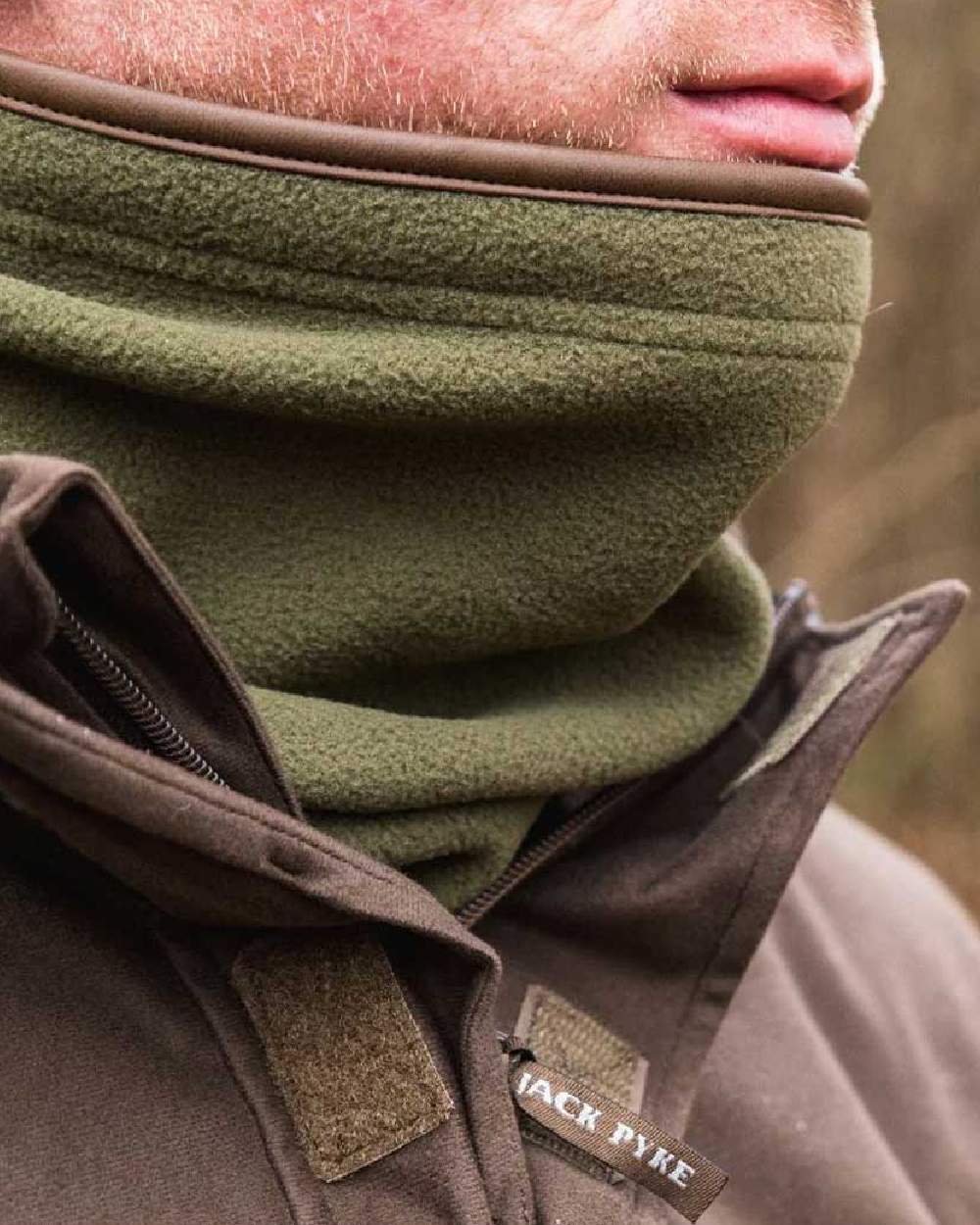 Light Olive coloured Jack Pyke Countryman Fleece Neck Gaiter on blurry background 