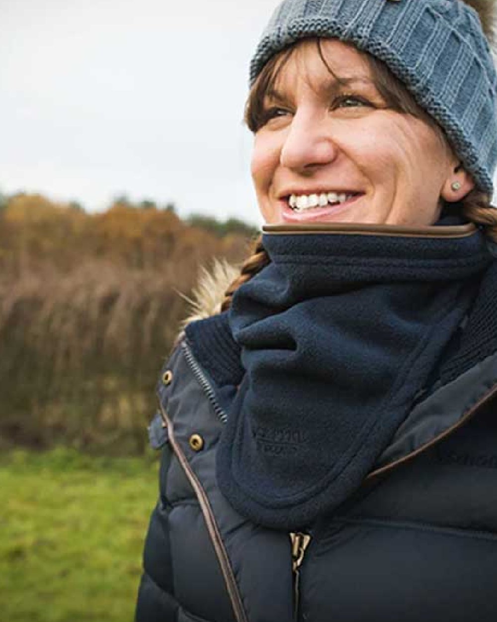 Navy coloured Jack Pyke Countryman Fleece Neck Gaiter on blurry background 