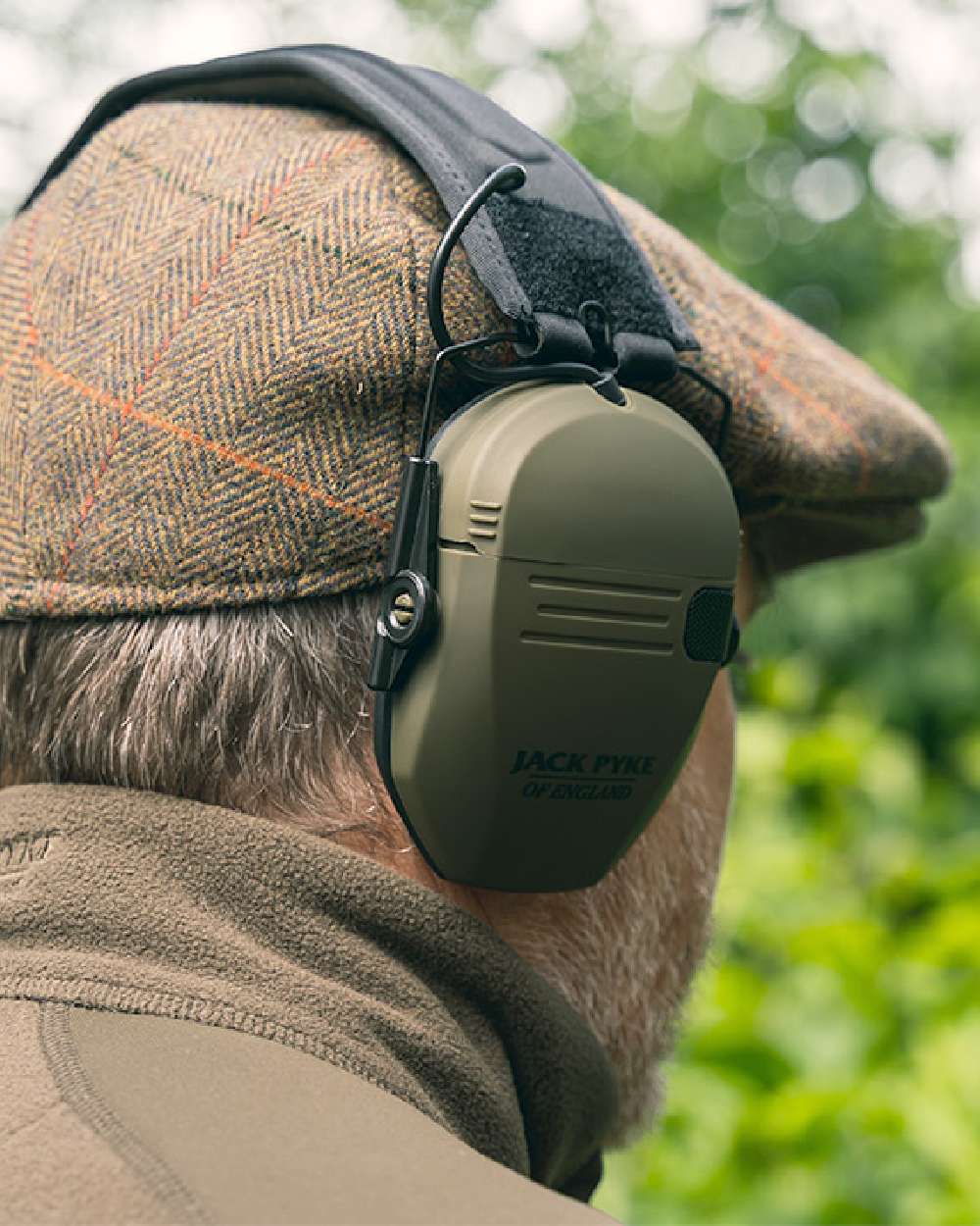 Green coloured Jack Pyke Electronic Ear Defenders on forest background 