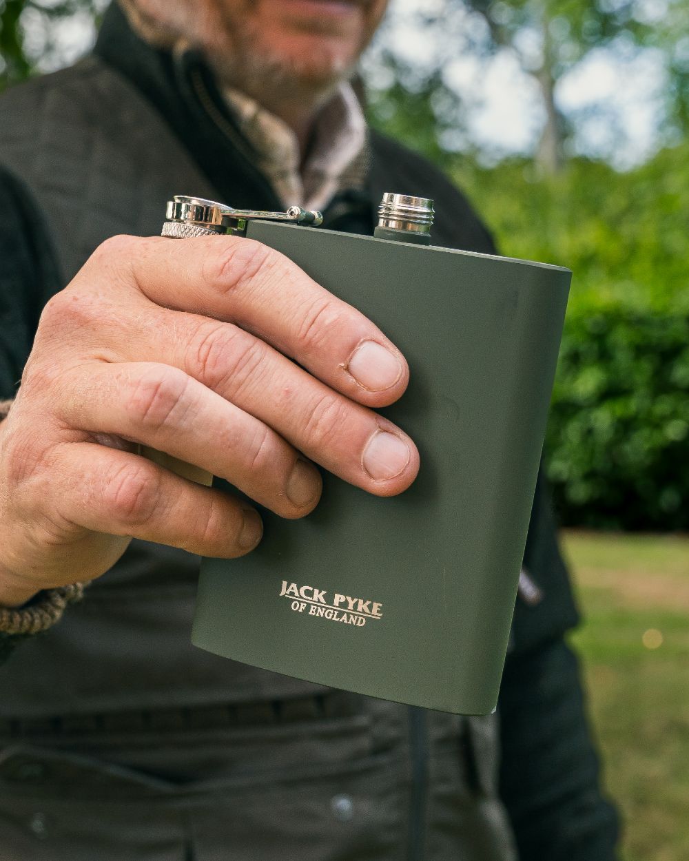 Green coloured Jack Pyke Hip Flask on forest background 