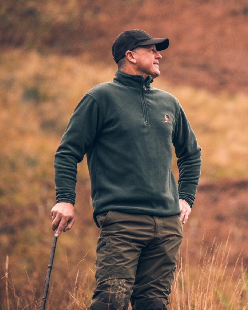 Green coloured Jack Pyke Pheasant Motif Fleece Pullover on blurry background 