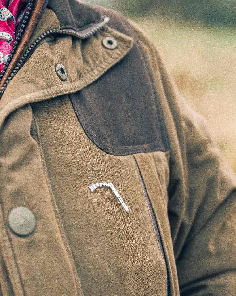 Shotgun styled Jack Pyke Pin Badge on blurry background 
