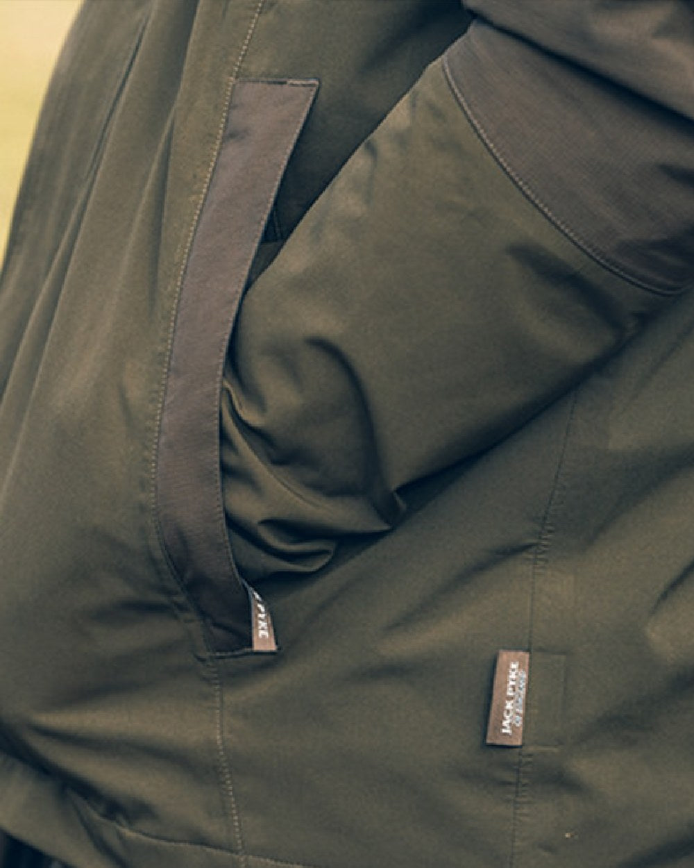 Green coloured Jack Pyke Pro-Lite Hunters Jacket on blurry background 