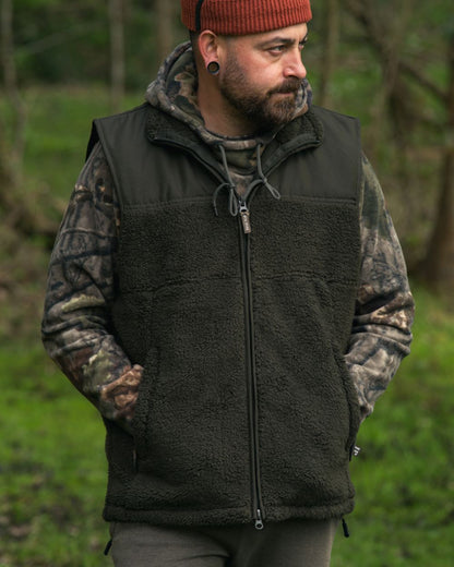 Dark Olive coloured Jack Pyke Sherpa Fleece Gilet on forest background 
