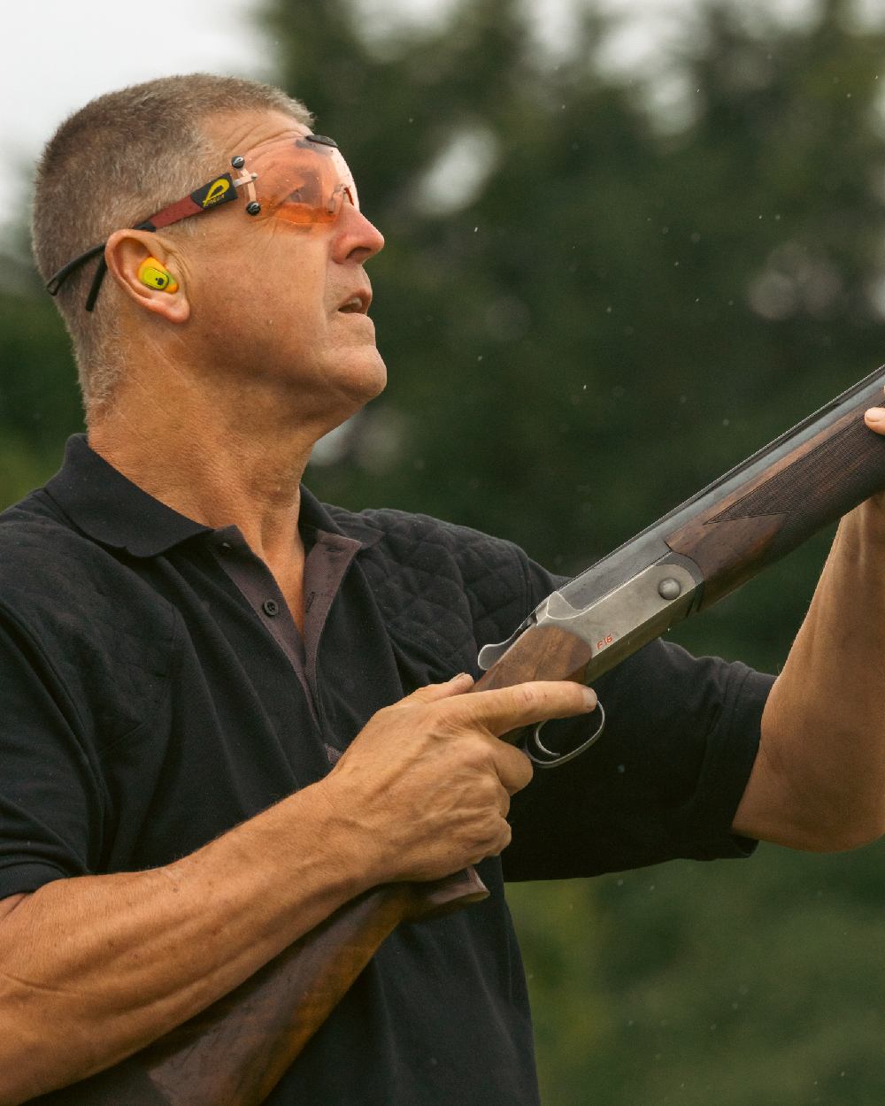 Black coloured Jack Pyke Sporting Polo Shirt on blurry background 