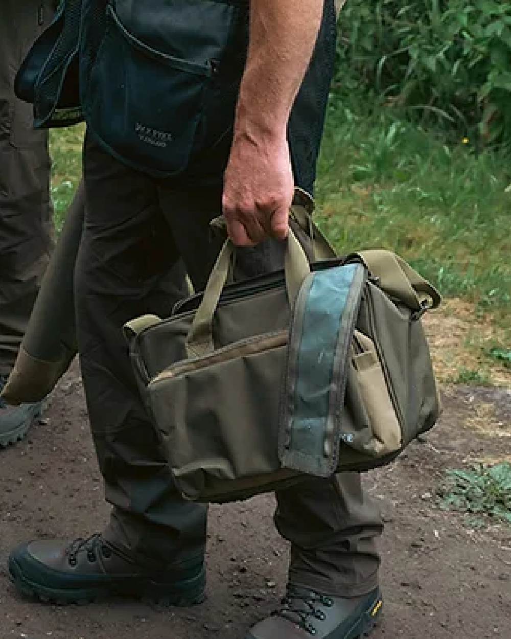 Green coloured Jack Pyke Sporting Shoulder Bag on mud background 