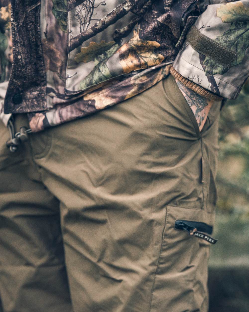 Green coloured Jack Pyke Weardale Hunting Trousers on forest background 
