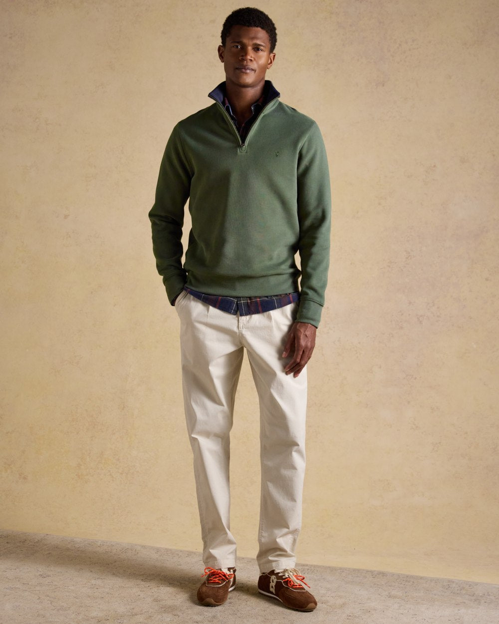 Khaki Green coloured Joules Alistair Quarter Zip Cotton Sweatshirt on wall background 