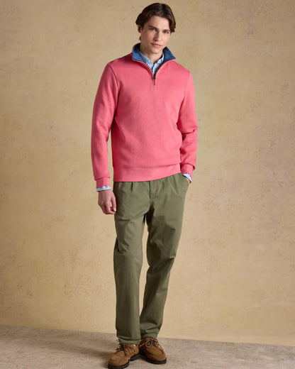 Pink coloured Joules Alistair Quarter Zip Cotton Sweatshirt on wall background 