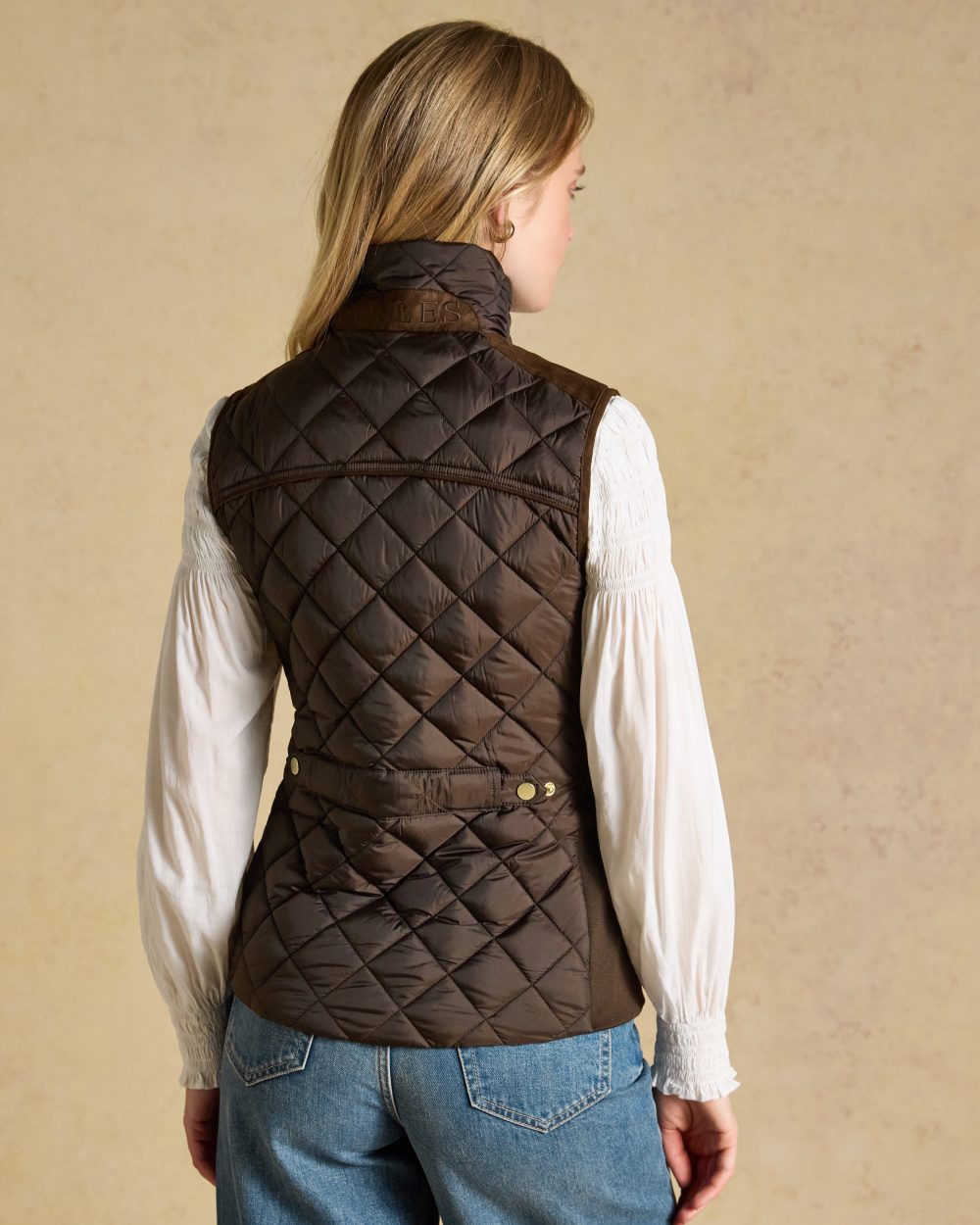 Chocolate Brown coloured Joules Braemar Luxe Gilet on tan background 