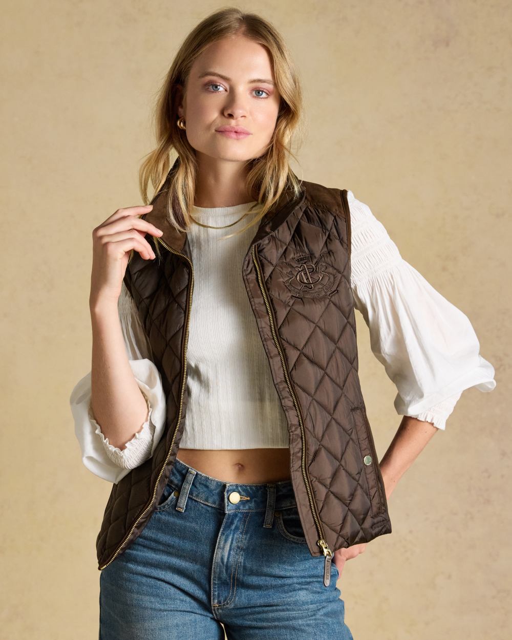 Chocolate Brown coloured Joules Braemar Luxe Gilet on tan background 