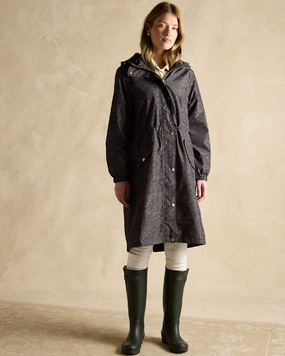 Black Coloured Joules Holkham Waterproof Packable Raincoat With Hood on indoor background 