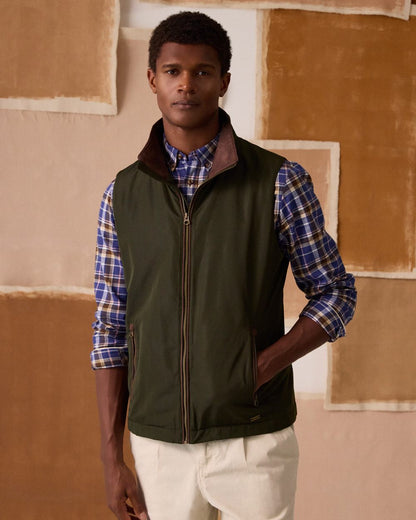 Green coloured Joules Mens Farnham Padded Fleece Lined Gilet on wall background 