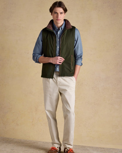 Green coloured Joules Mens Farnham Padded Fleece Lined Gilet on wall background 