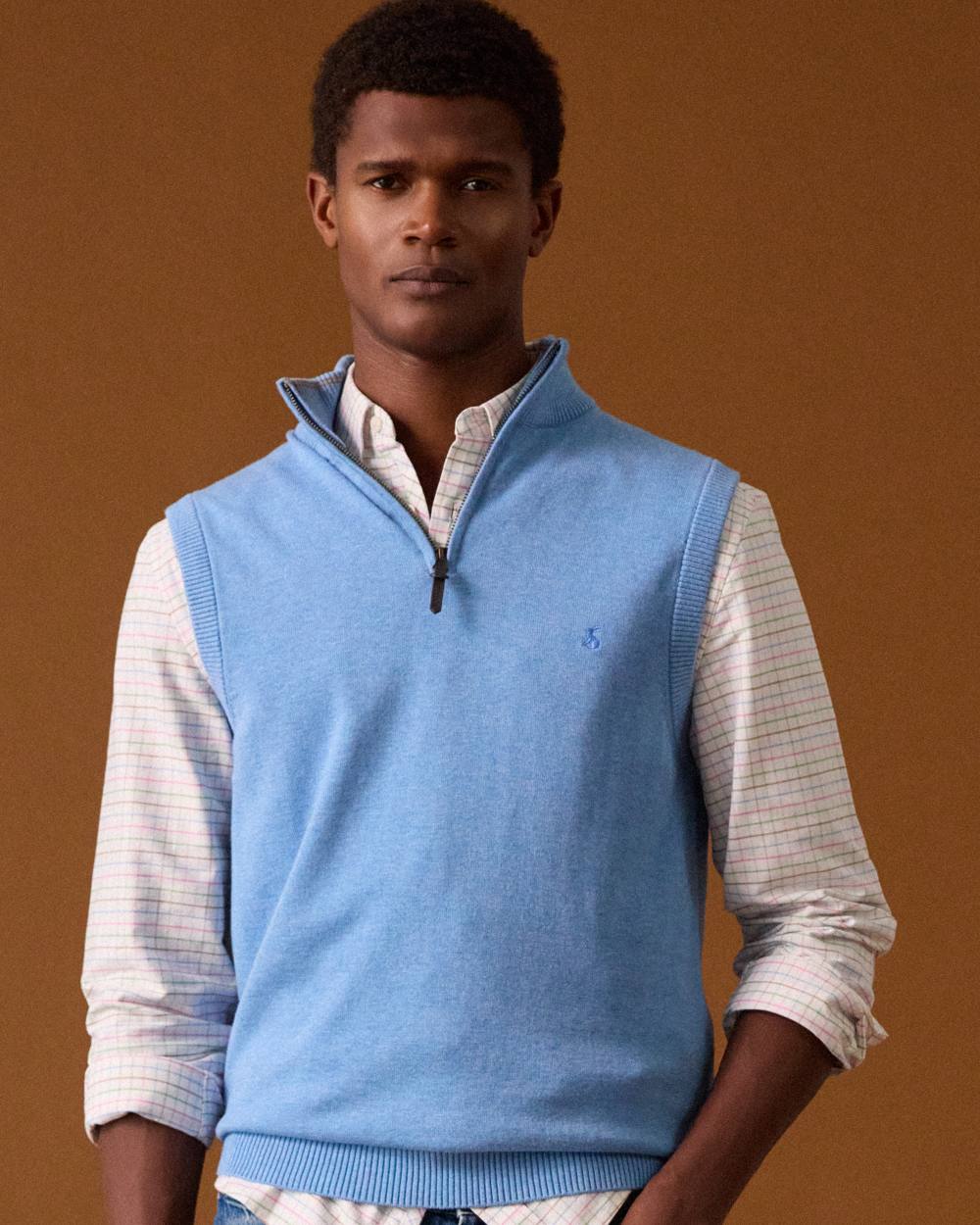 Light Blue coloured Joules Mens Hillside Quarter Zip Knitted Tank Top on wall background 