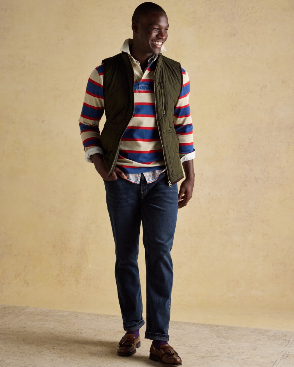 Green coloured Joules Mens Maynard Diamond Quilted Gilet on wall background 