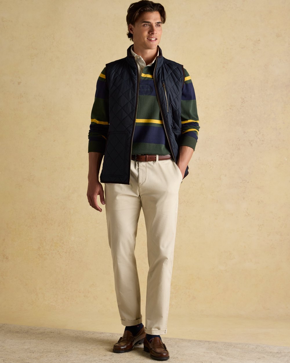 Navy coloured Joules Mens Maynard Diamond Quilted Gilet on wall background 