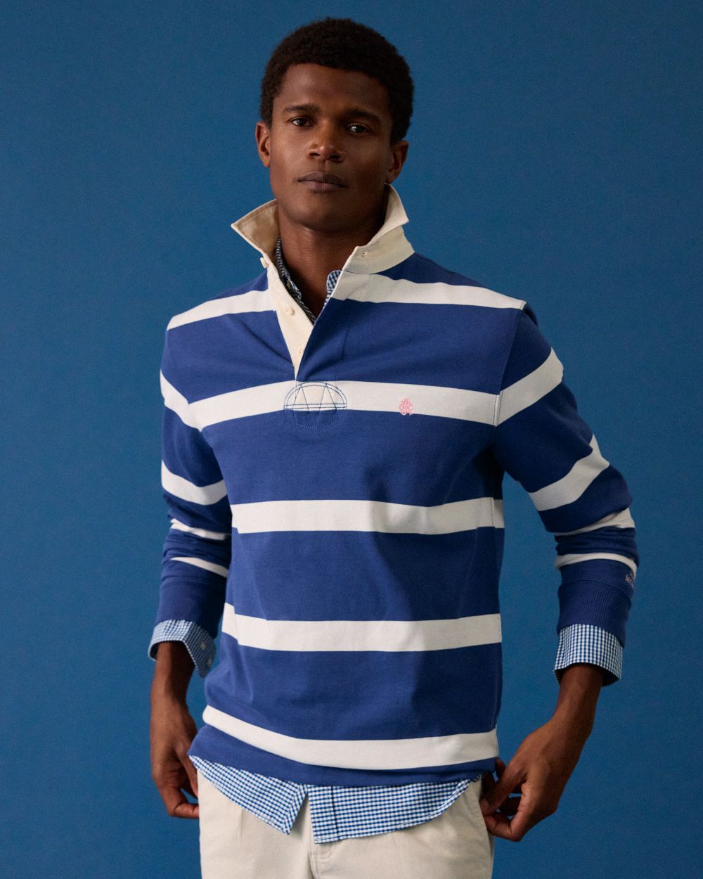Blue Cream Coloured Joules Mens Onside Rugby Shirt on wall background 