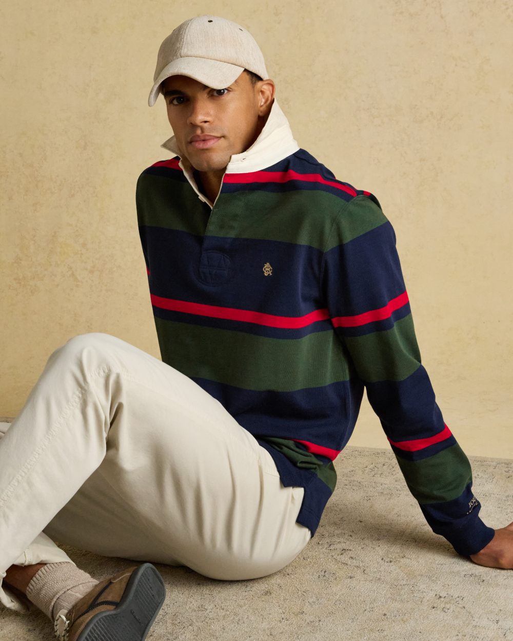 Navy Green Coloured Joules Mens Onside Rugby Shirt on wall background 