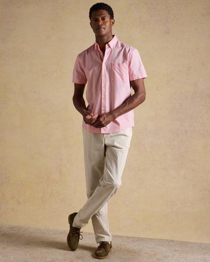 Pink coloured Joules Mens Oxford Short Sleeve Classic Fit Cotton Shirt on wall background 