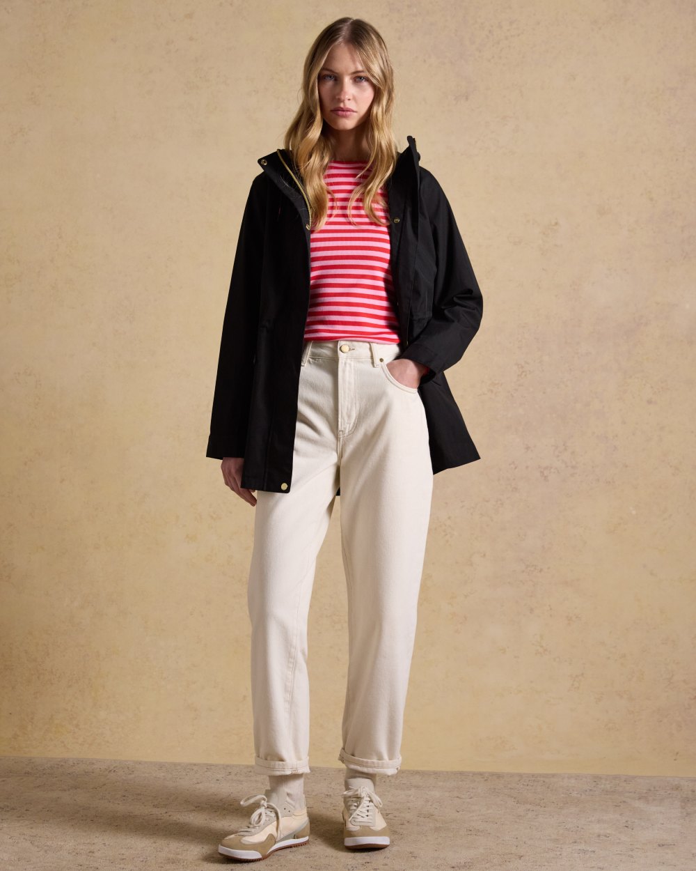 Black Coloured Joules Portwell Waterproof Raincoat With Hood On A Wall Background 