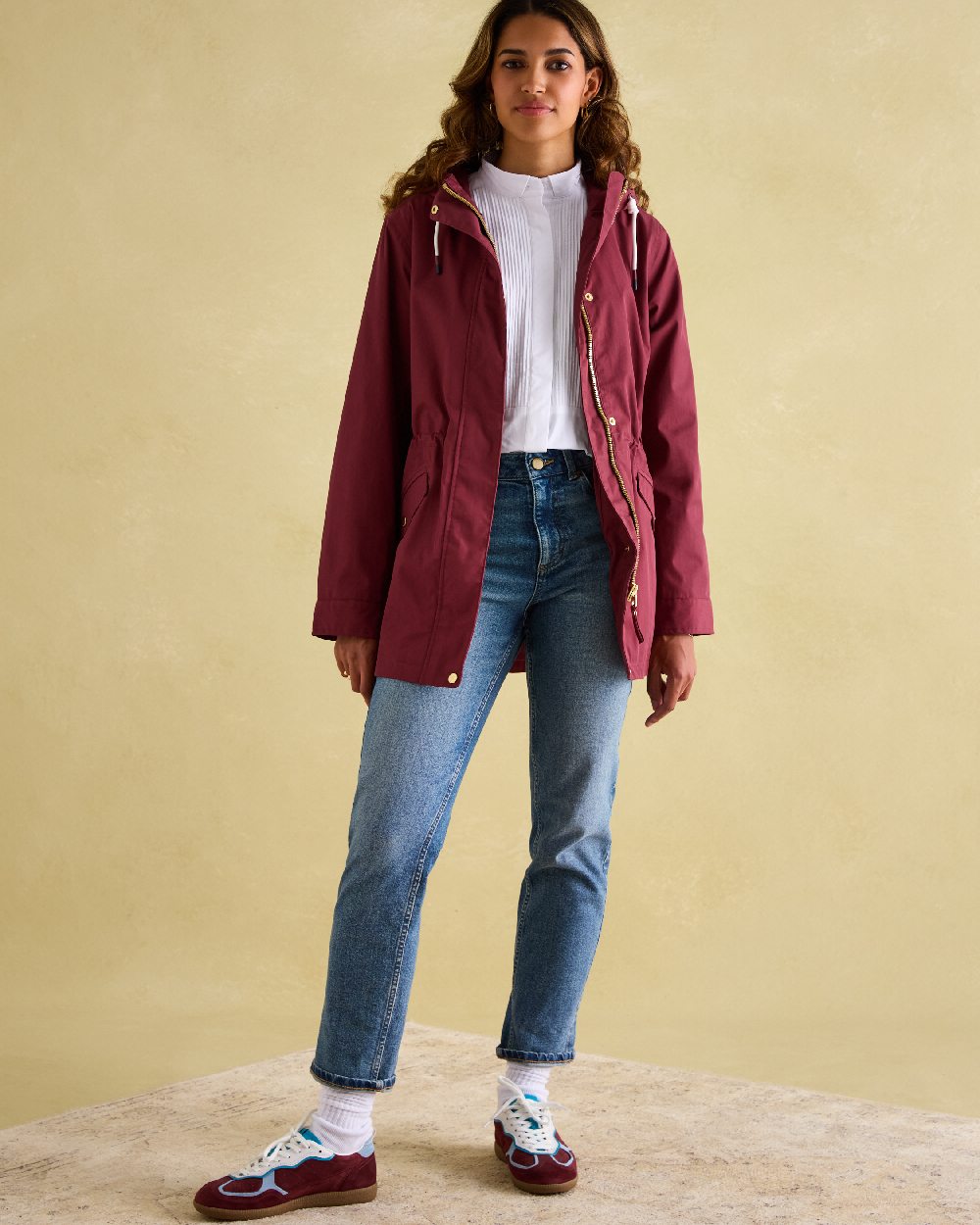 Oxblood Coloured Joules Portwell Waterproof Raincoat With Hood on indoor background 