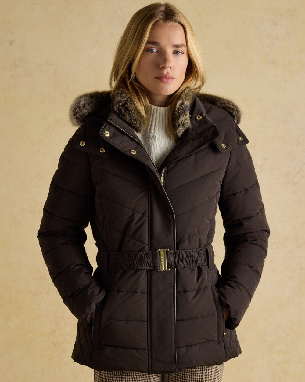 Brown Coloured Joules Womens Aspen Showerproof Padded Coat on wall background 