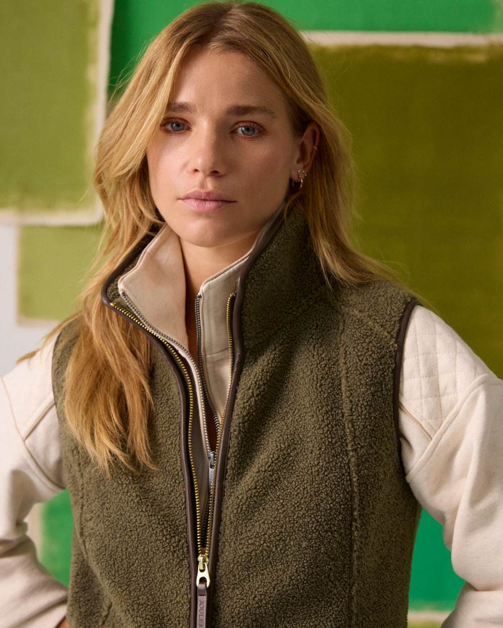 Khaki Green coloured Joules Womens Borg Heritage Fleece Gilet on textured background 