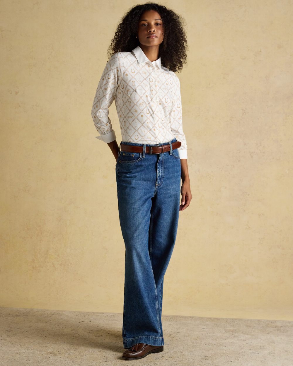 White coloured Joules Womens Charlotte Horse Icons Printed Jersey Shirt on wall background 