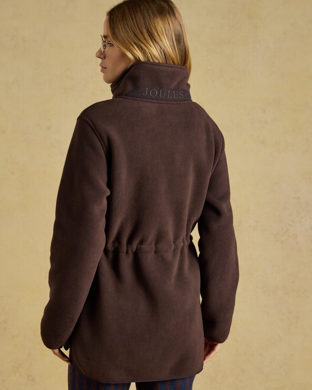 Chocolate Brown coloured Joules Womens Full Zip Longline Fleece Jacket on indoor background 