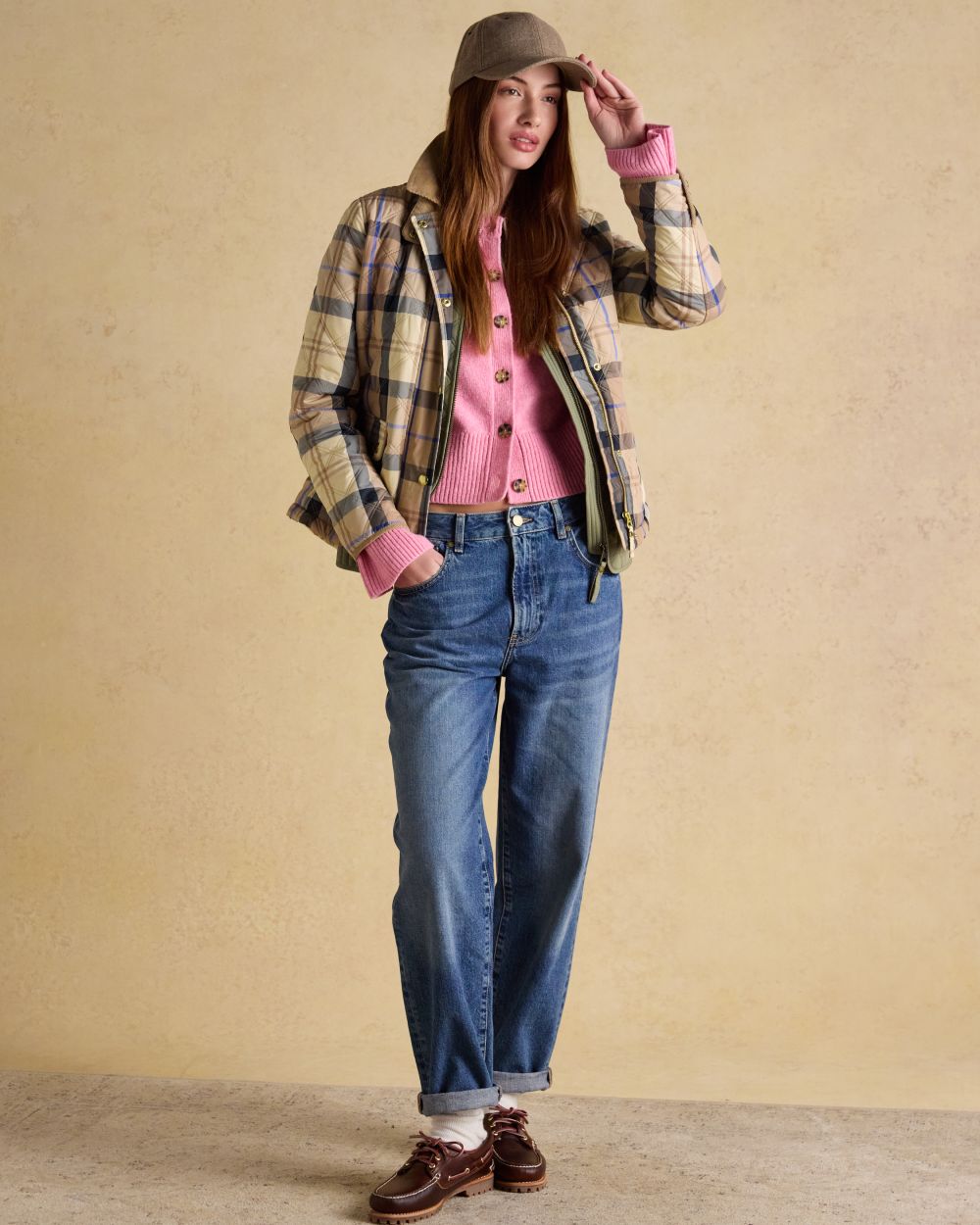 Brown check coloured Joules Womens Harrogate Showerproof Diamond Quilted Barn Jacket on wall background 