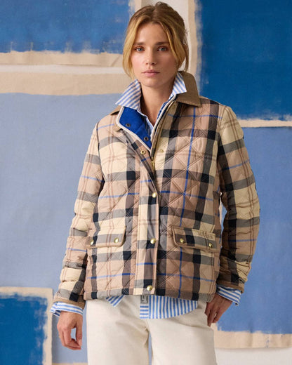 Brown check coloured Joules Womens Harrogate Showerproof Diamond Quilted Barn Jacket on wall background 