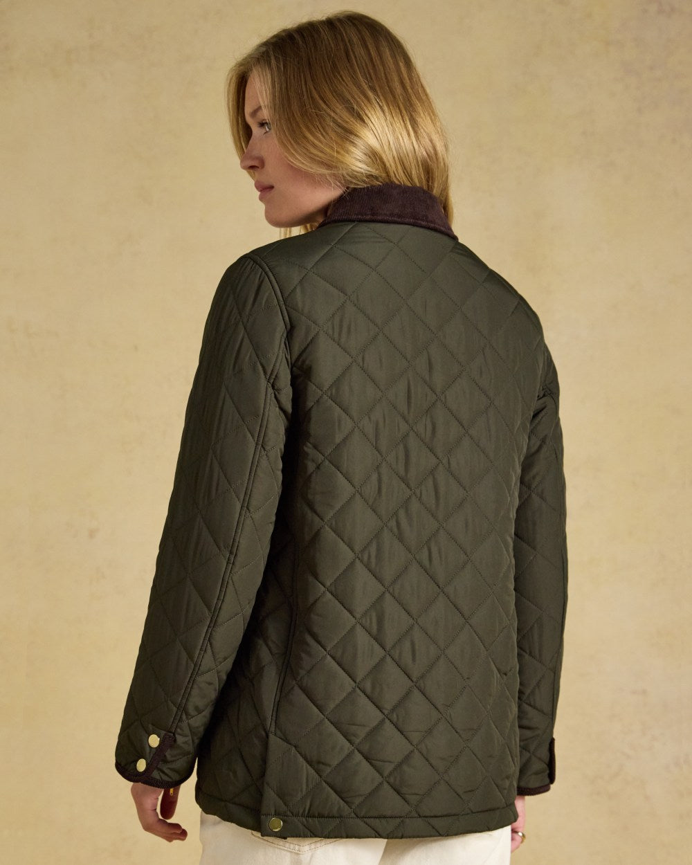 Khaki Green coloured Joules Womens Highgrove Diamond Quilted Jacket on beige background 
