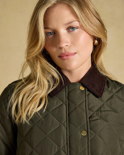 Khaki Green coloured Joules Womens Highgrove Diamond Quilted Jacket on beige background 