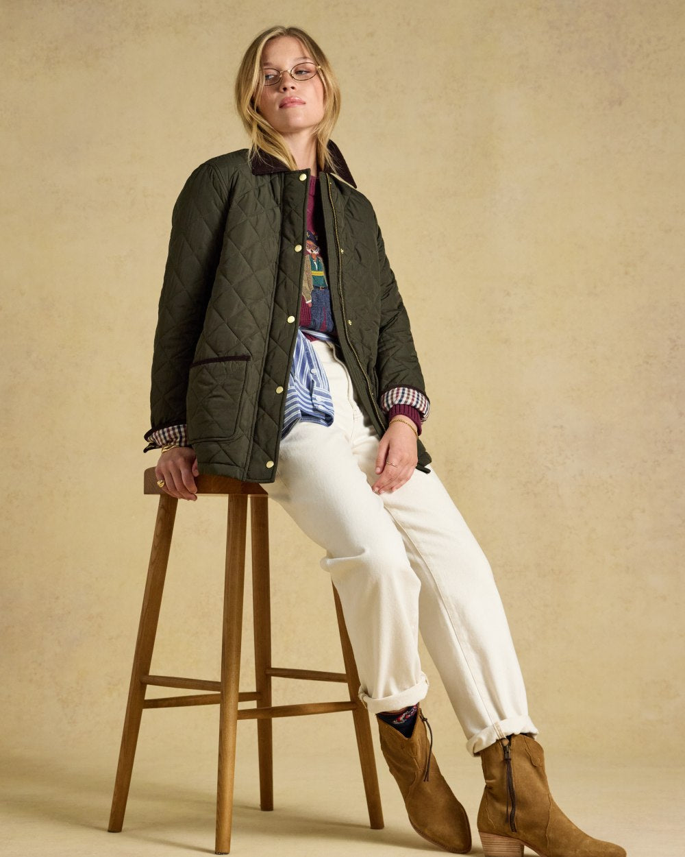 Khaki Green coloured Joules Womens Highgrove Diamond Quilted Jacket on beige background 