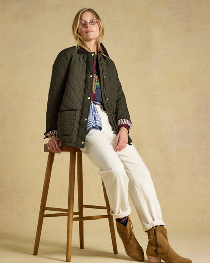 Khaki Green coloured Joules Womens Highgrove Diamond Quilted Jacket on beige background 