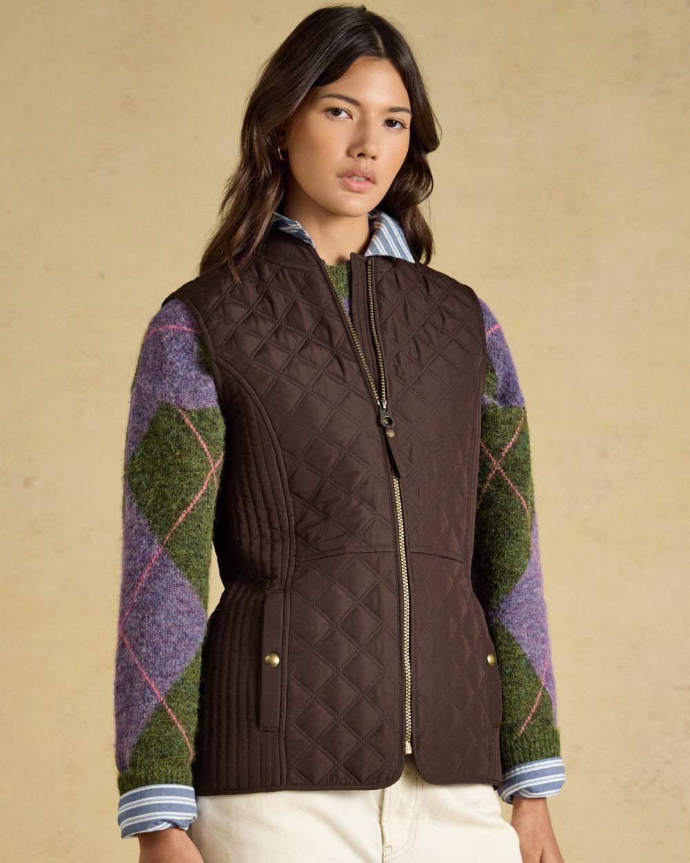 Chocolate Brown Coloured Joules Minx Showerproof Diamond Quilted Gilet on wall background 