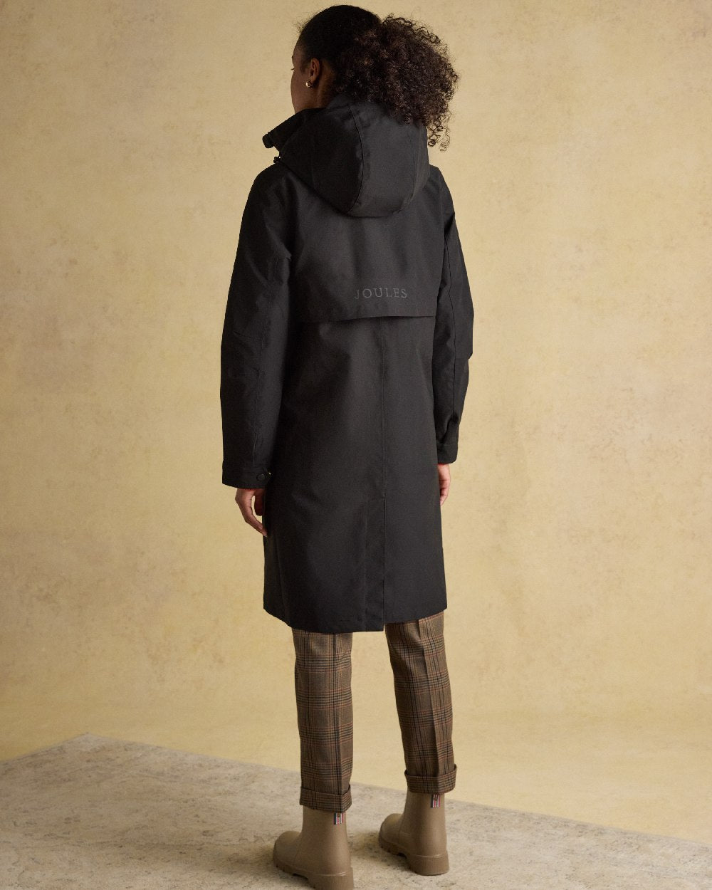 Black Coloured Joules Womens Rainaway Waterproof Longline Raincoat on indoor background 