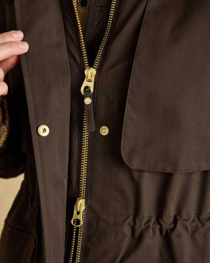 Chocolate Brown coloured Joules Womens Warmwell Waterproof Fleece Lined Raincoat on tan background 