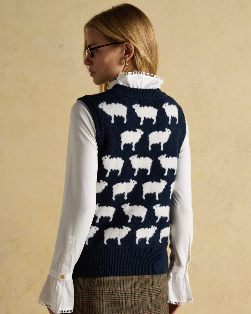 Navy coloured Joules Womens What The Flock Intarsia Knitted Vest on wall background 