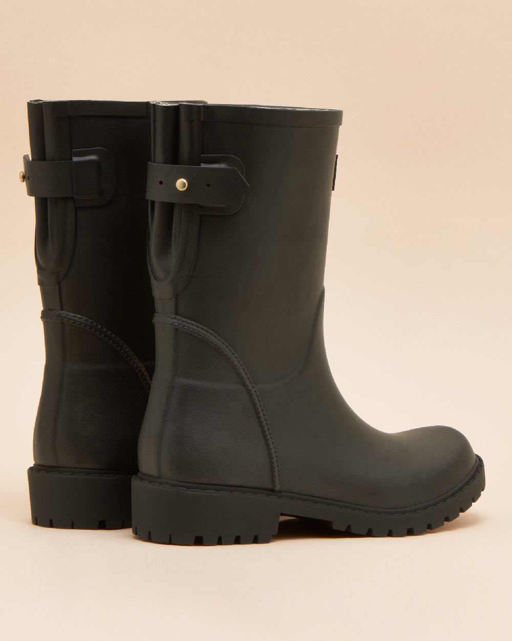 Black coloured Joules Womens Wistow Adjustable Mid Calf Wellies on tan background 