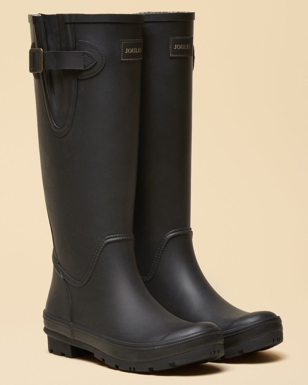 Black coloured Joules Womens Houghton Adjustable Tall Wellies on tan background 